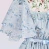 短い袖および花およびリボンの印刷物が付いている軽い青いシフォンの服